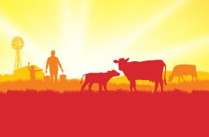 Silhouette of a farmer carrying buckets walking among cows and a calf in a grassy field at sunrise, with a windmill and barn in the background under a bright yellow sky—a serene glimpse into the origins behind CPG package production.